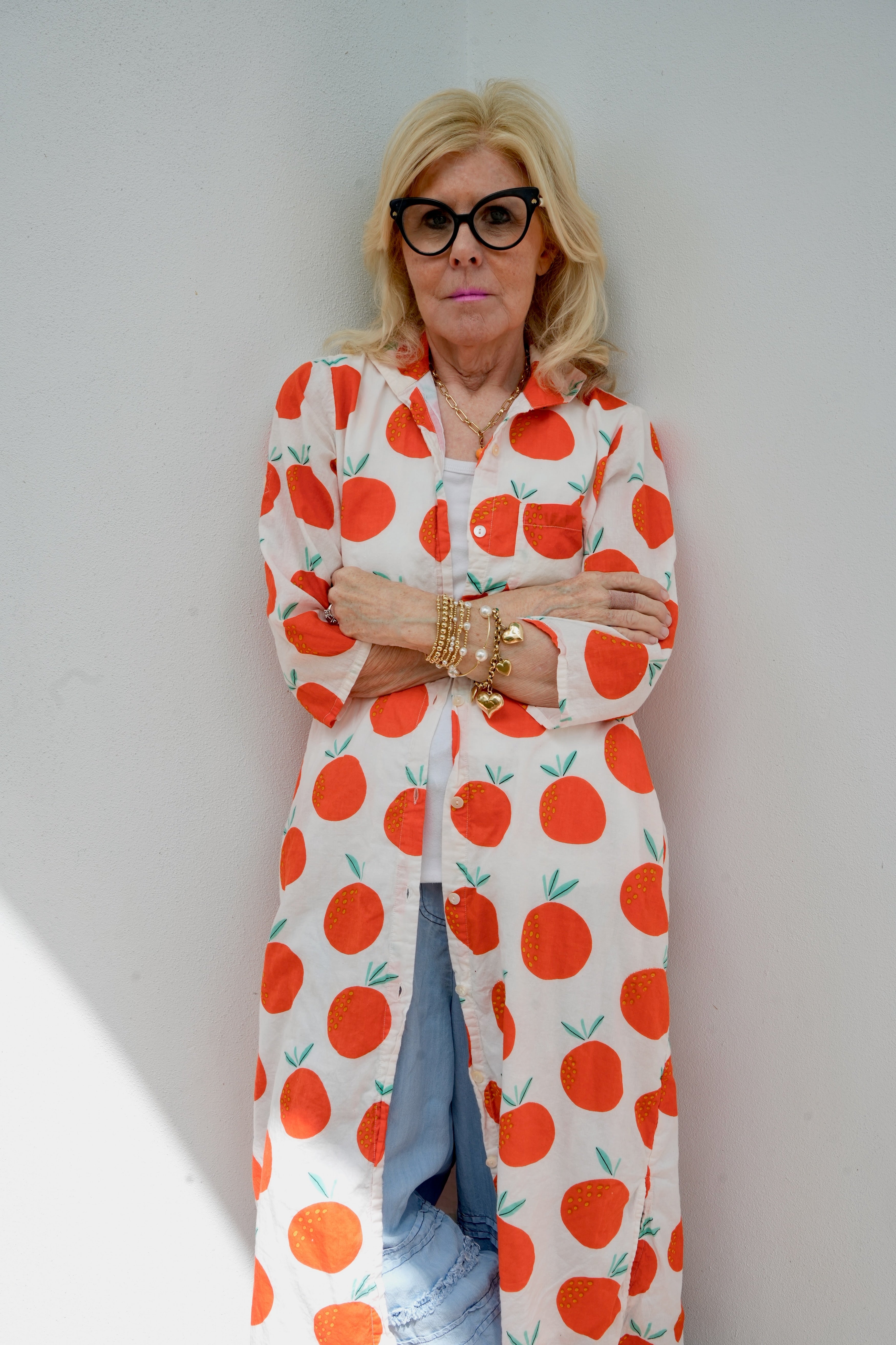 Person wearing a white outfit with oranges pattern against a plain background