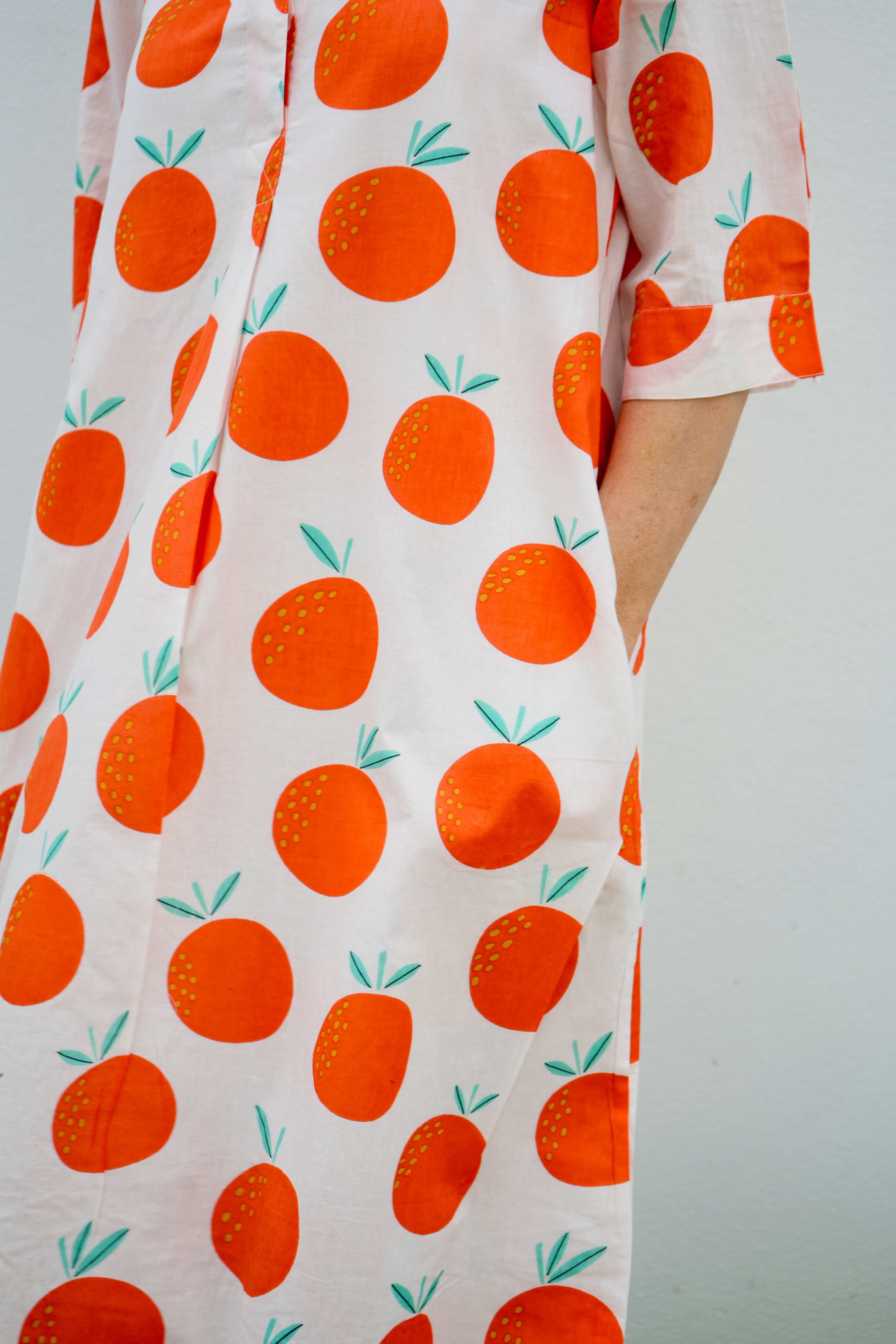 Dress with orange fruit pattern on a plain background