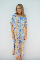 Woman wearing a patterned dress against a plain background