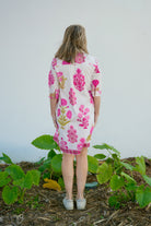 Person wearing a floral dress standing in a garden